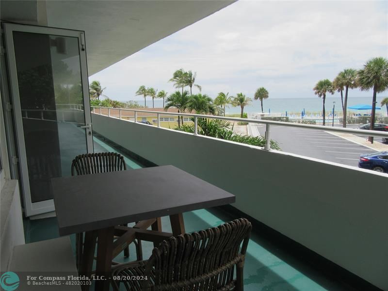 a view of a balcony with a table and chairs