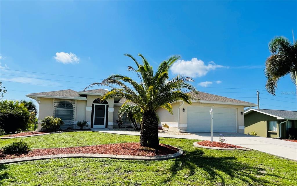 a palm tree sitting in front of a house with yard