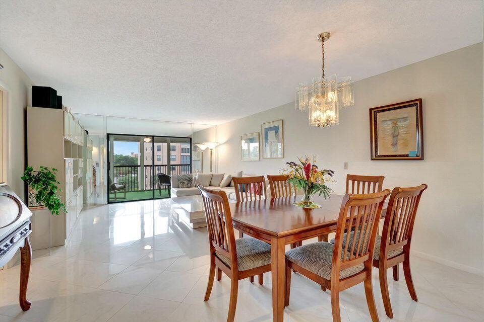 a dining room with furniture a chandelier and window