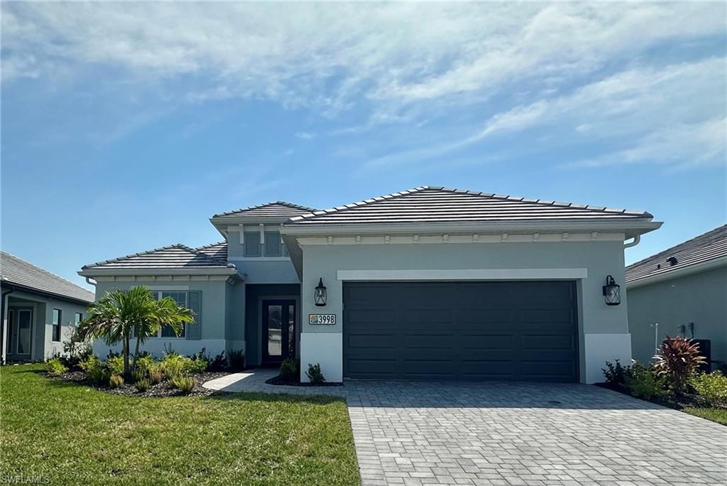 View of front of house featuring a front lawn and a garage