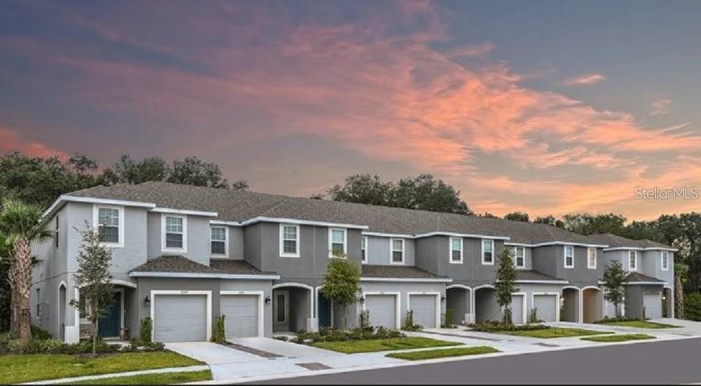 a front view of a residential apartment building with a yard