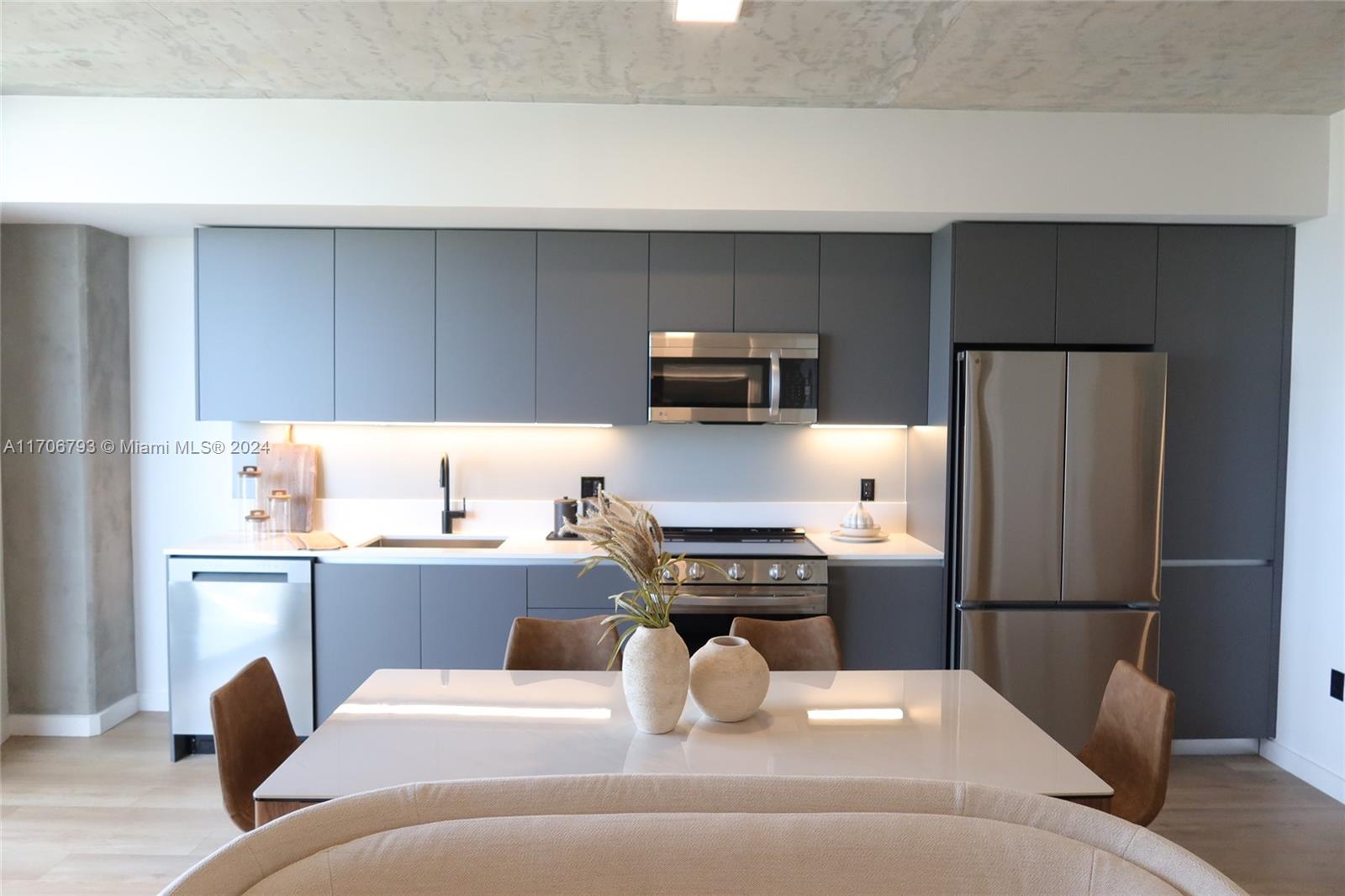 a kitchen with a refrigerator and a stove top oven