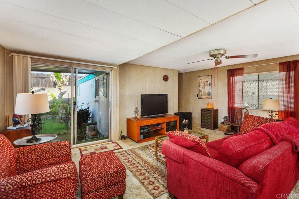 a living room with furniture a flat screen tv and a floor to ceiling window