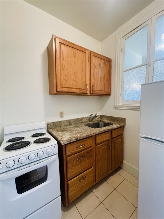 a kitchen with granite countertop cabinets and white appliances