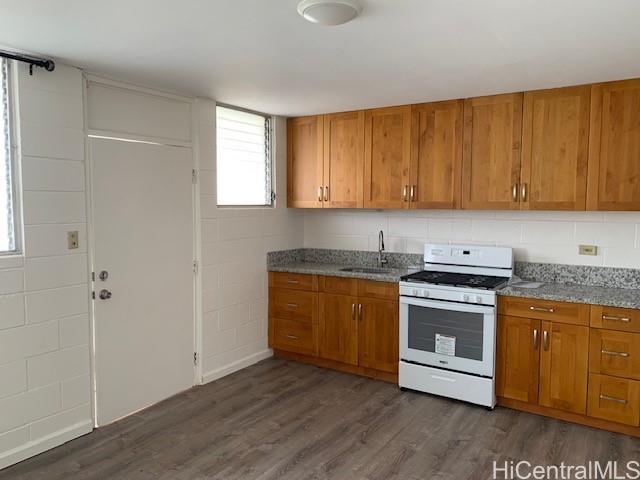 a kitchen with granite countertop wooden cabinets and white appliances