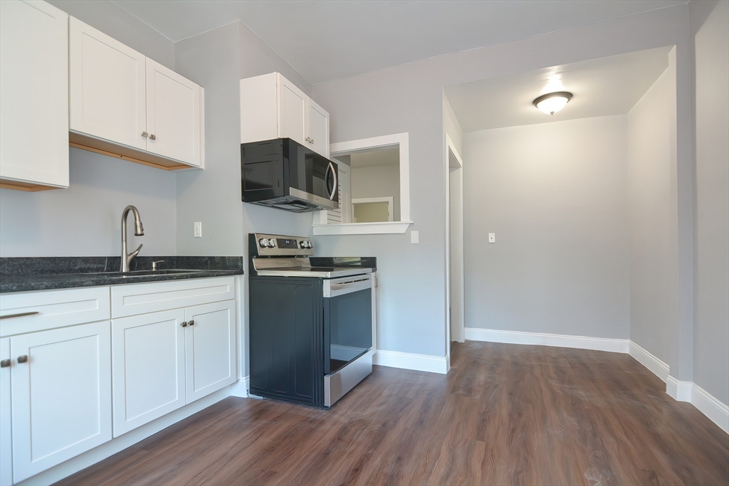 a kitchen with a refrigerator and a stove top oven