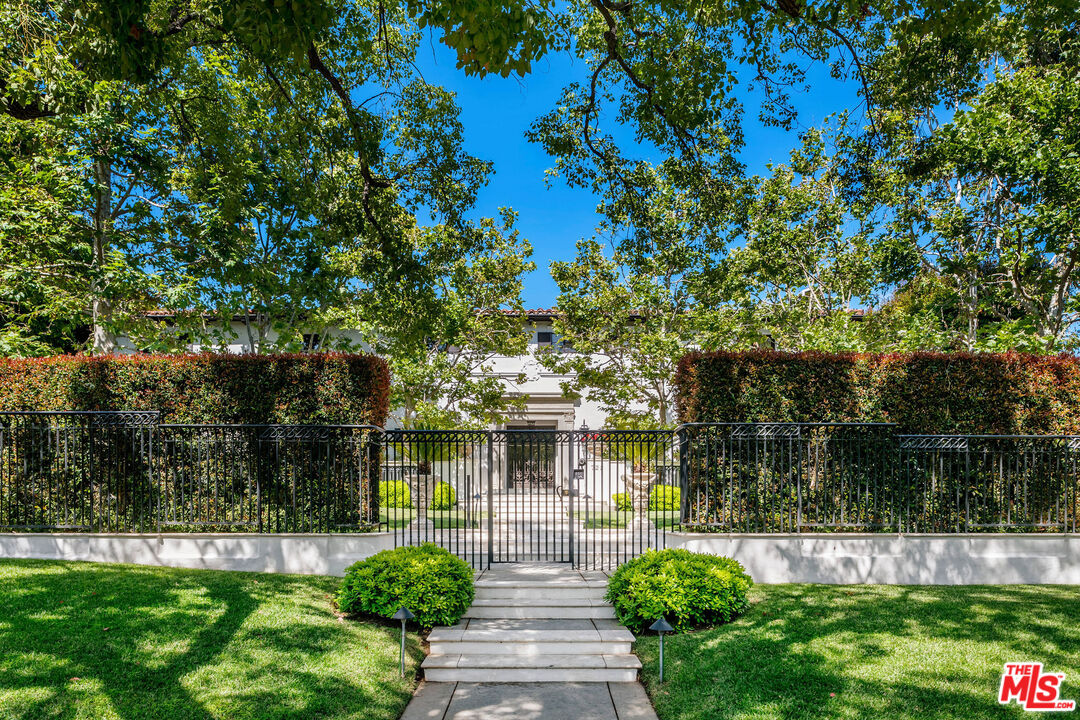 a front view of a house with garden and plants