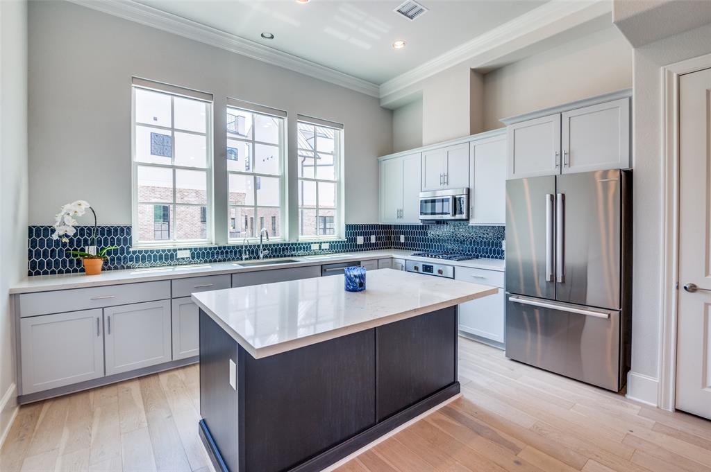 a kitchen with kitchen island granite countertop a sink stove and refrigerator