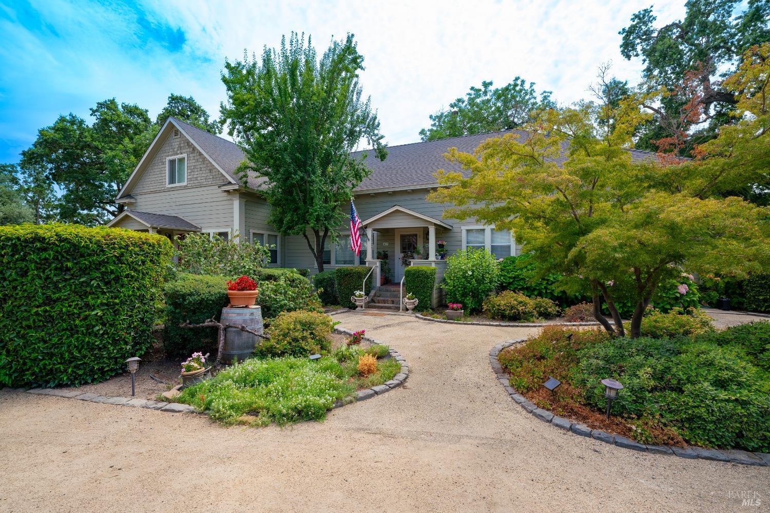 a front view of a house with a yard and potted plants