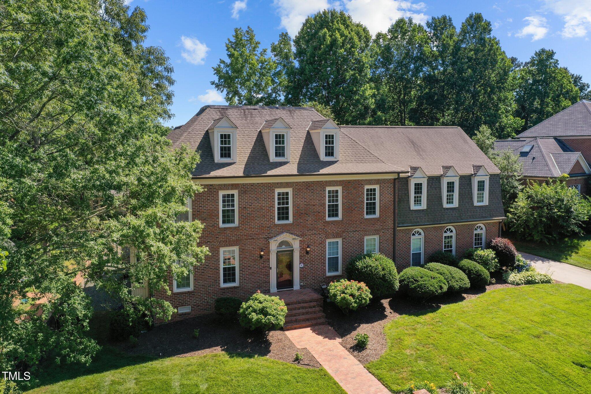 a aerial view of a brick house next to a yard