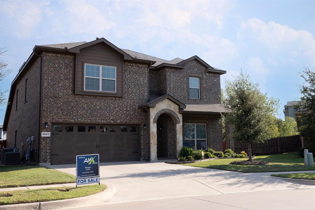 View of front of house with a front yard, a garage, and central AC unit