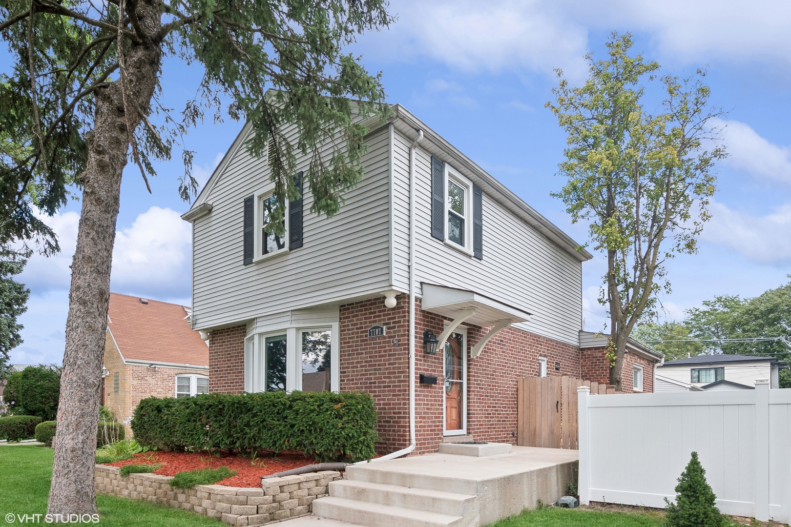 a front view of a house with a tree