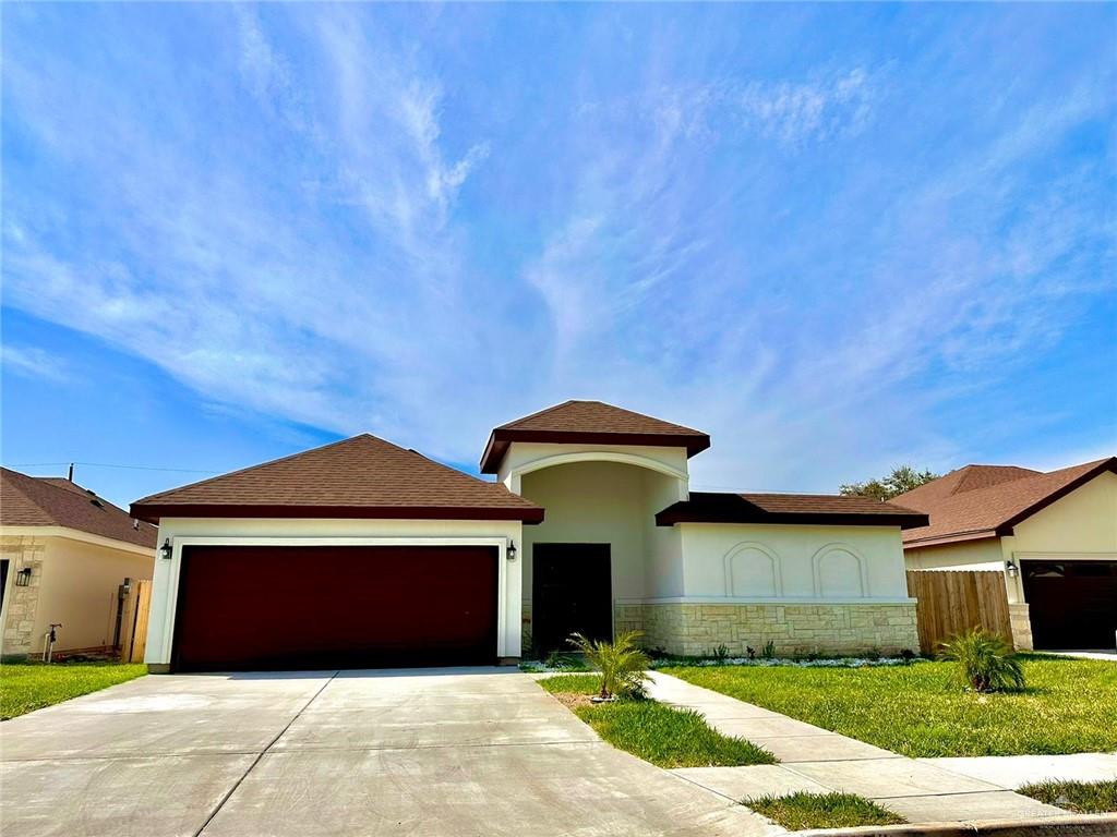 a front view of a house with a yard and garage