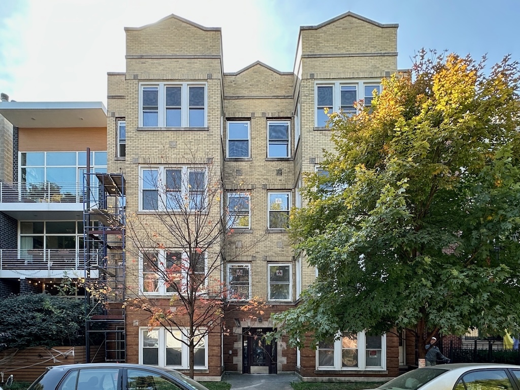 a front view of a residential apartment building with a yard