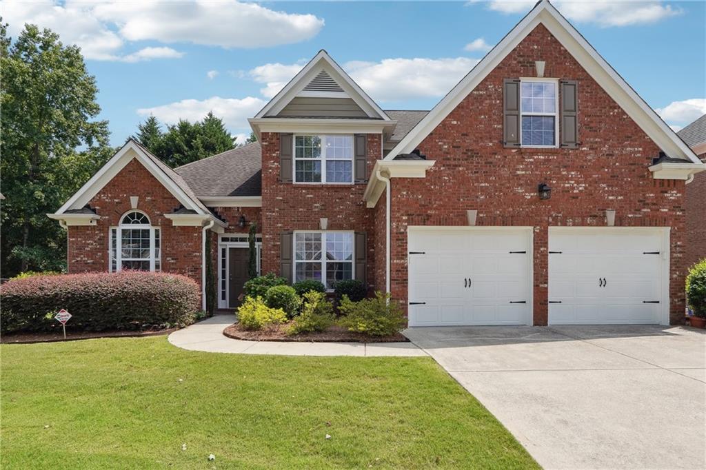 a front view of a house with a yard and garage