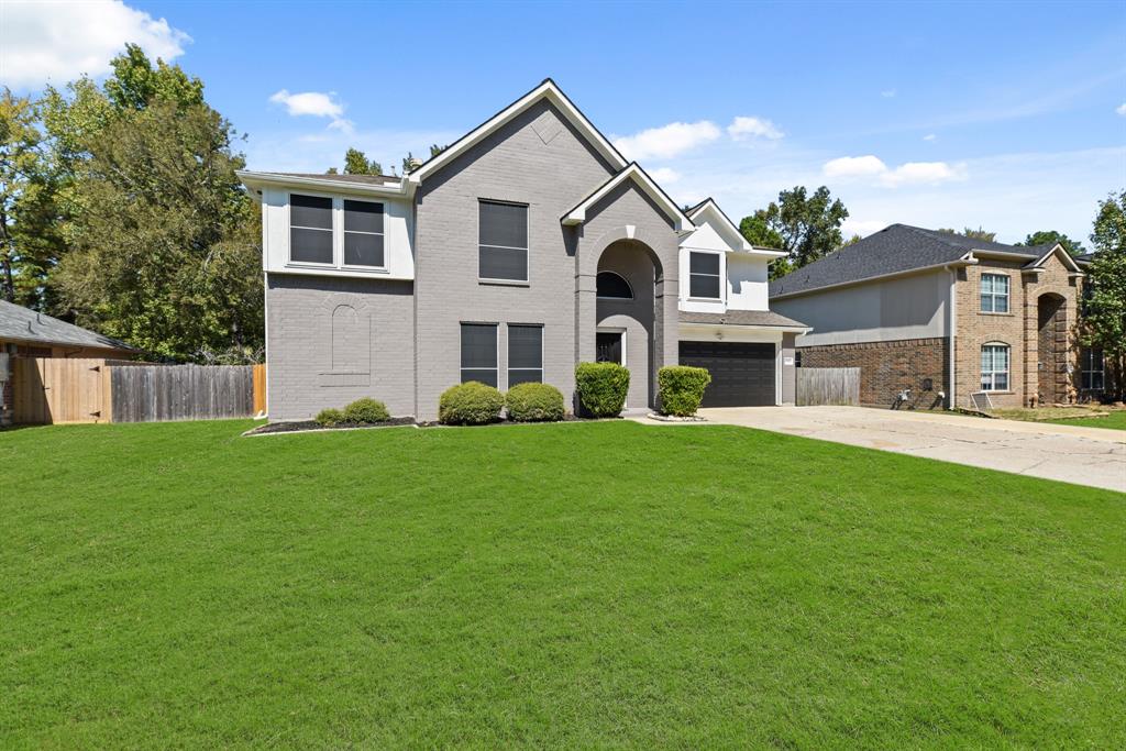 a front view of a house with a garden and yard