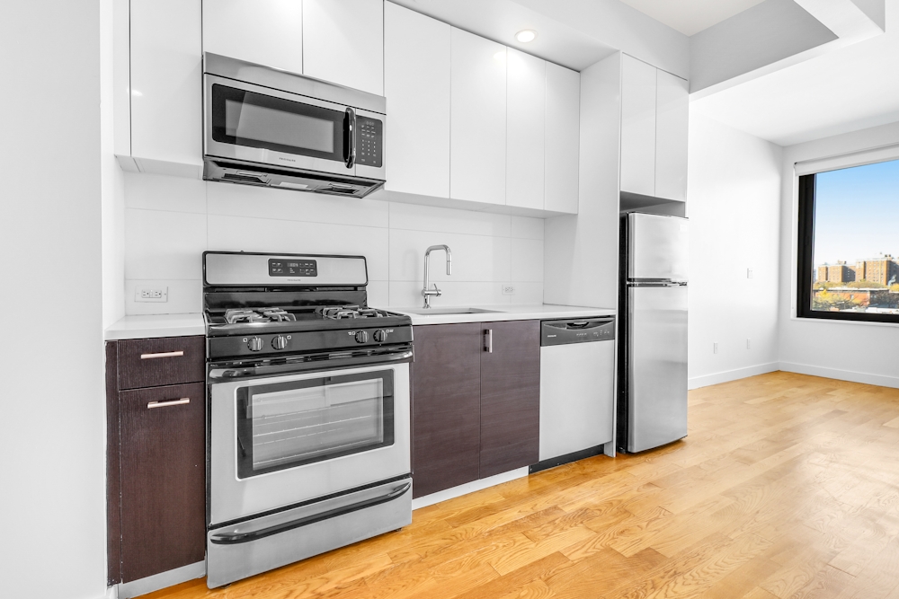 a kitchen with stainless steel appliances granite countertop a stove microwave and refrigerator