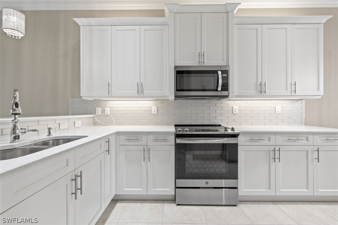 a kitchen with white cabinets and stainless steel appliances