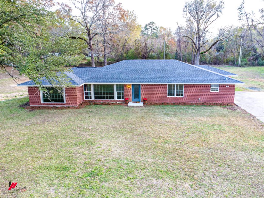 a front view of house with yard and trees around