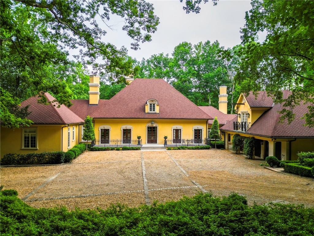 a view of a white house with a big yard and potted plants