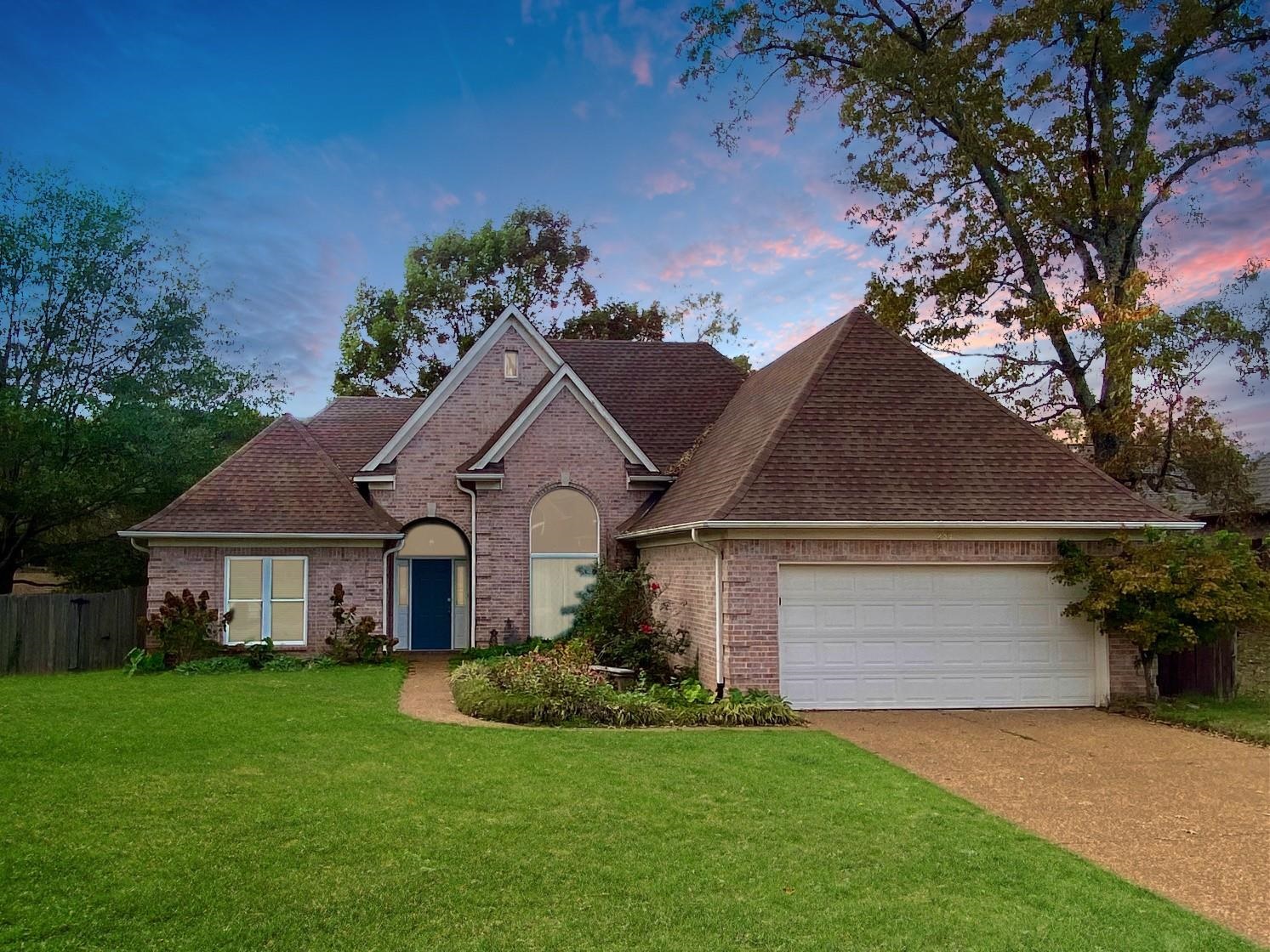 View of front of home featuring a lawn and a garage