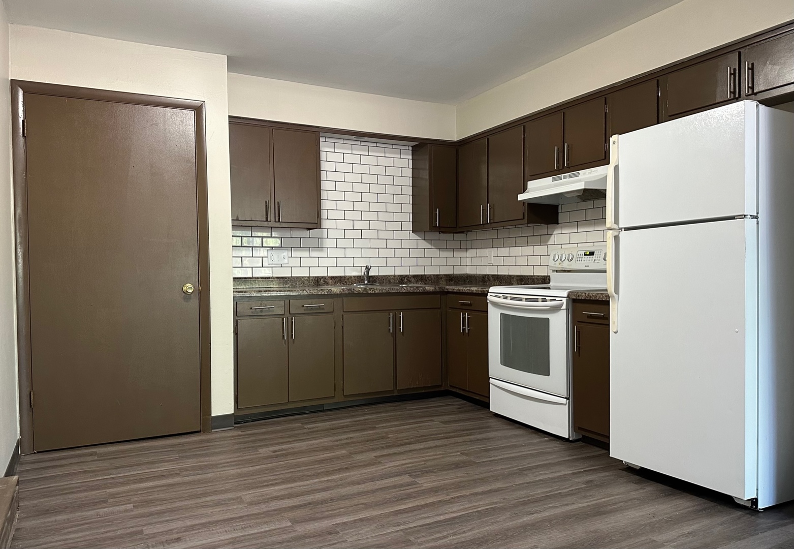 a kitchen with stainless steel appliances a sink a stove a refrigerator and cabinets