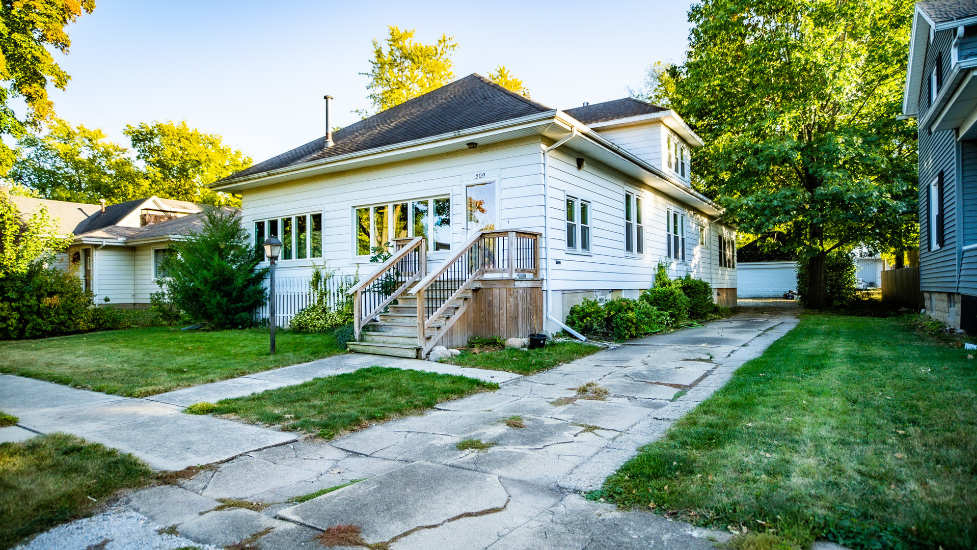 a front view of a house with a yard and trees