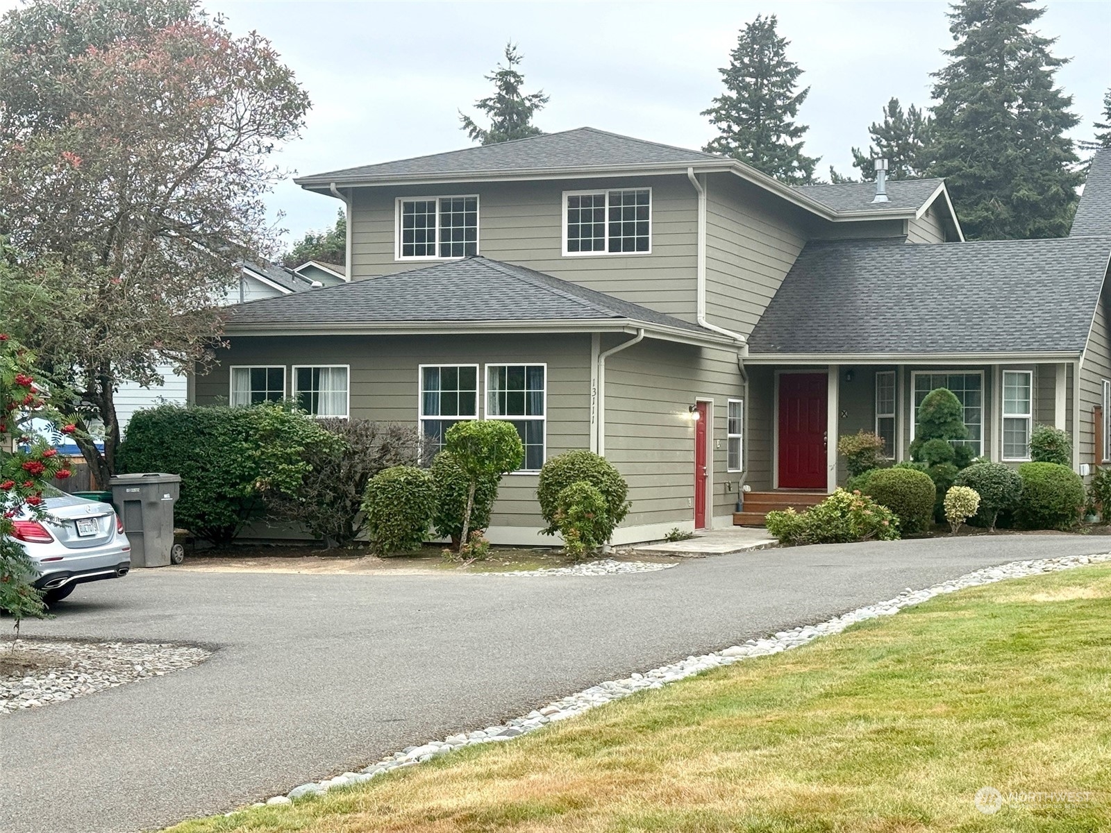 a front view of a house with a yard and potted plants