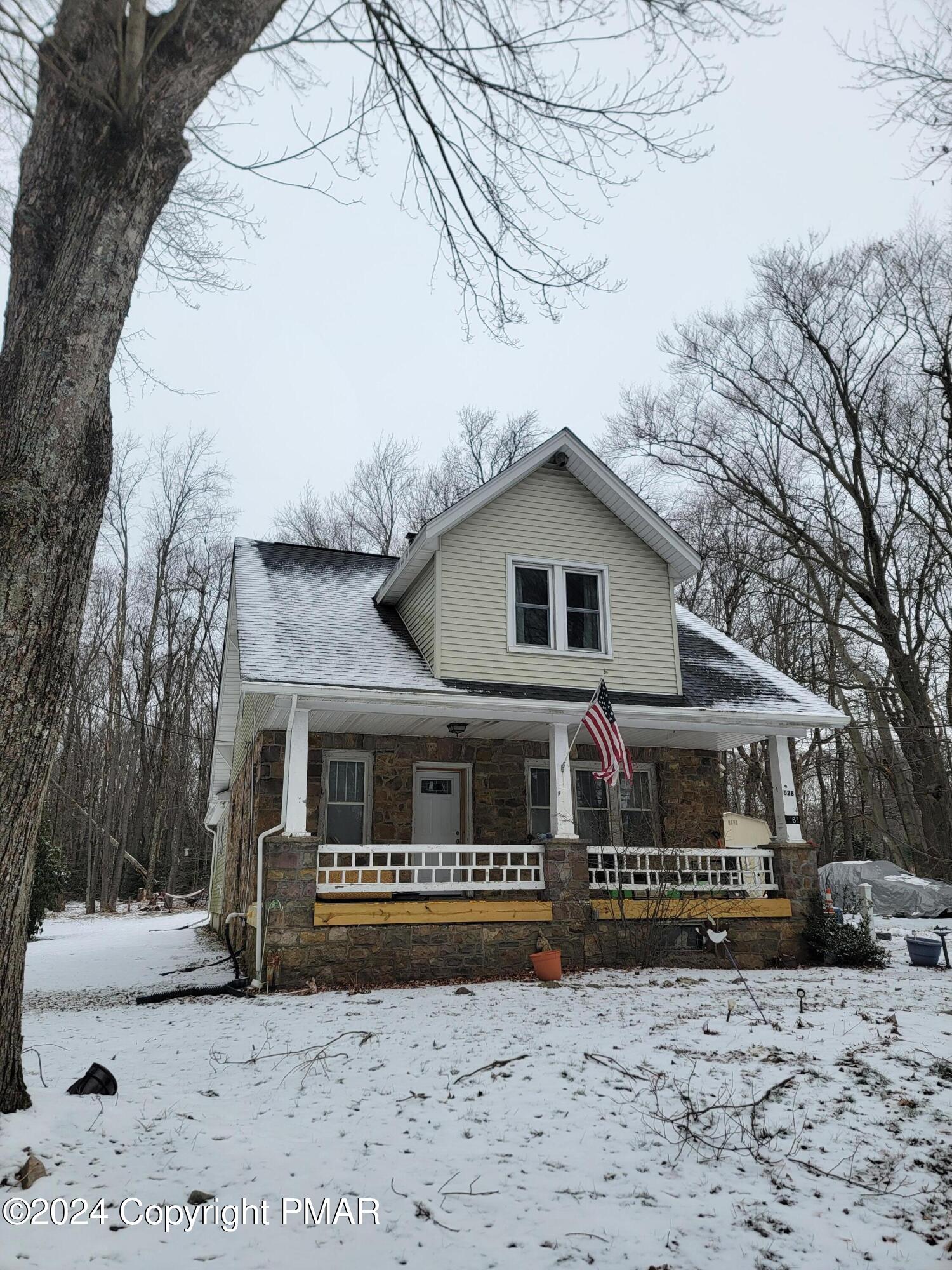 a front view of a house with a yard covered with snow