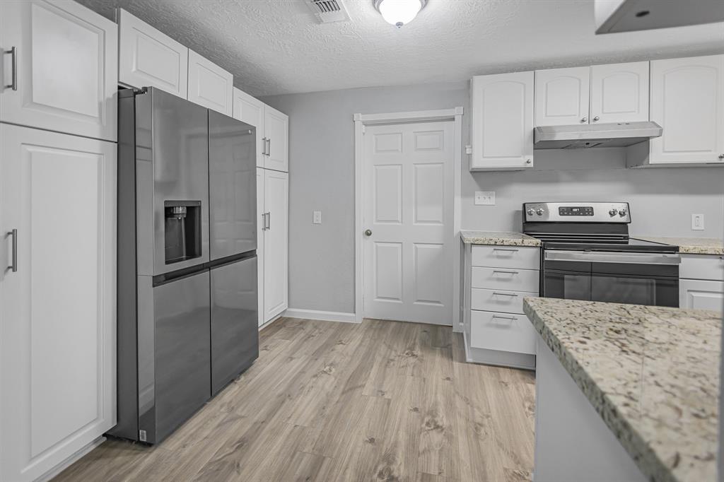 a kitchen with a refrigerator sink and wooden floor