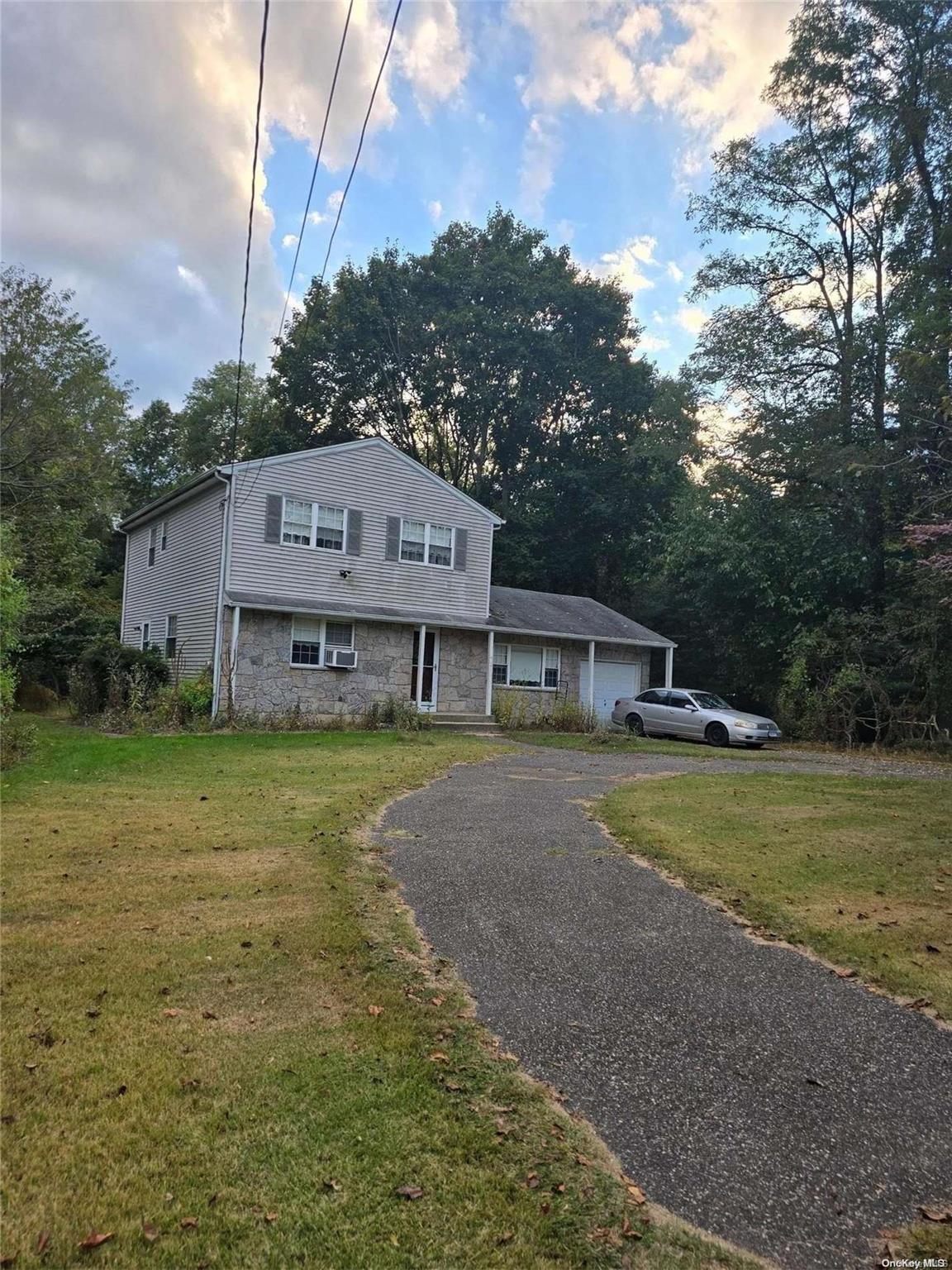 a front view of a house with a garden and yard