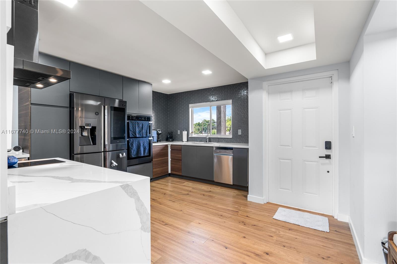 a large kitchen with kitchen island a sink stainless steel appliances and cabinets