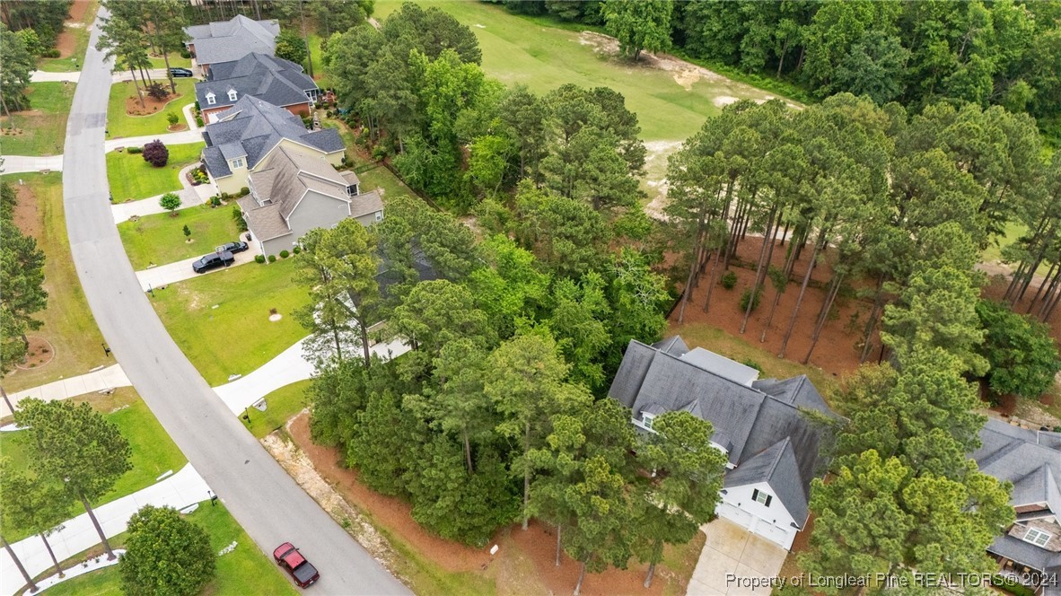 an aerial view of residential house with outdoor space and trees all around