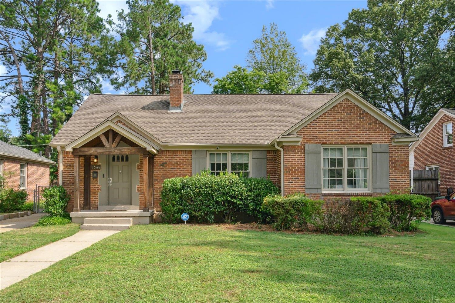 a front view of a house with a garden and yard