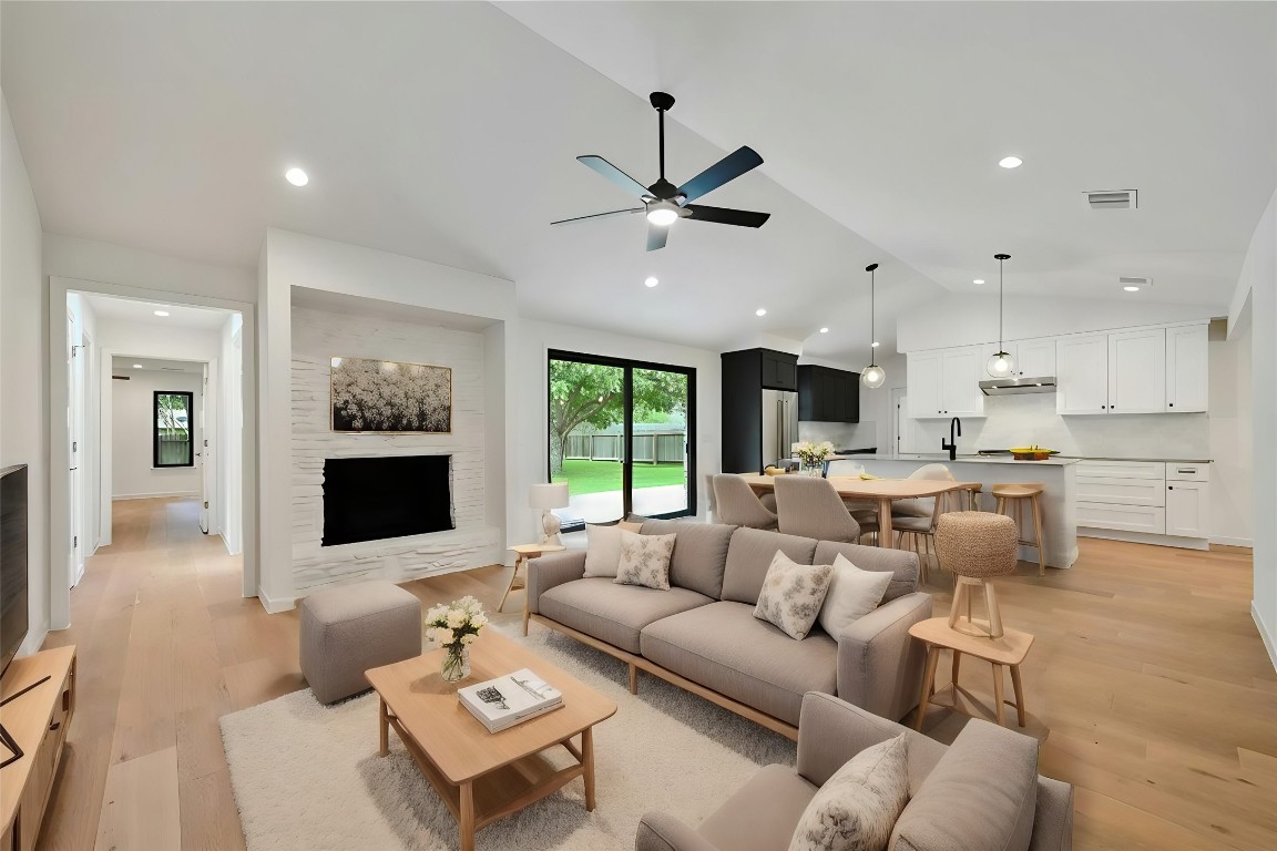 a living room with furniture kitchen view and a flat screen tv