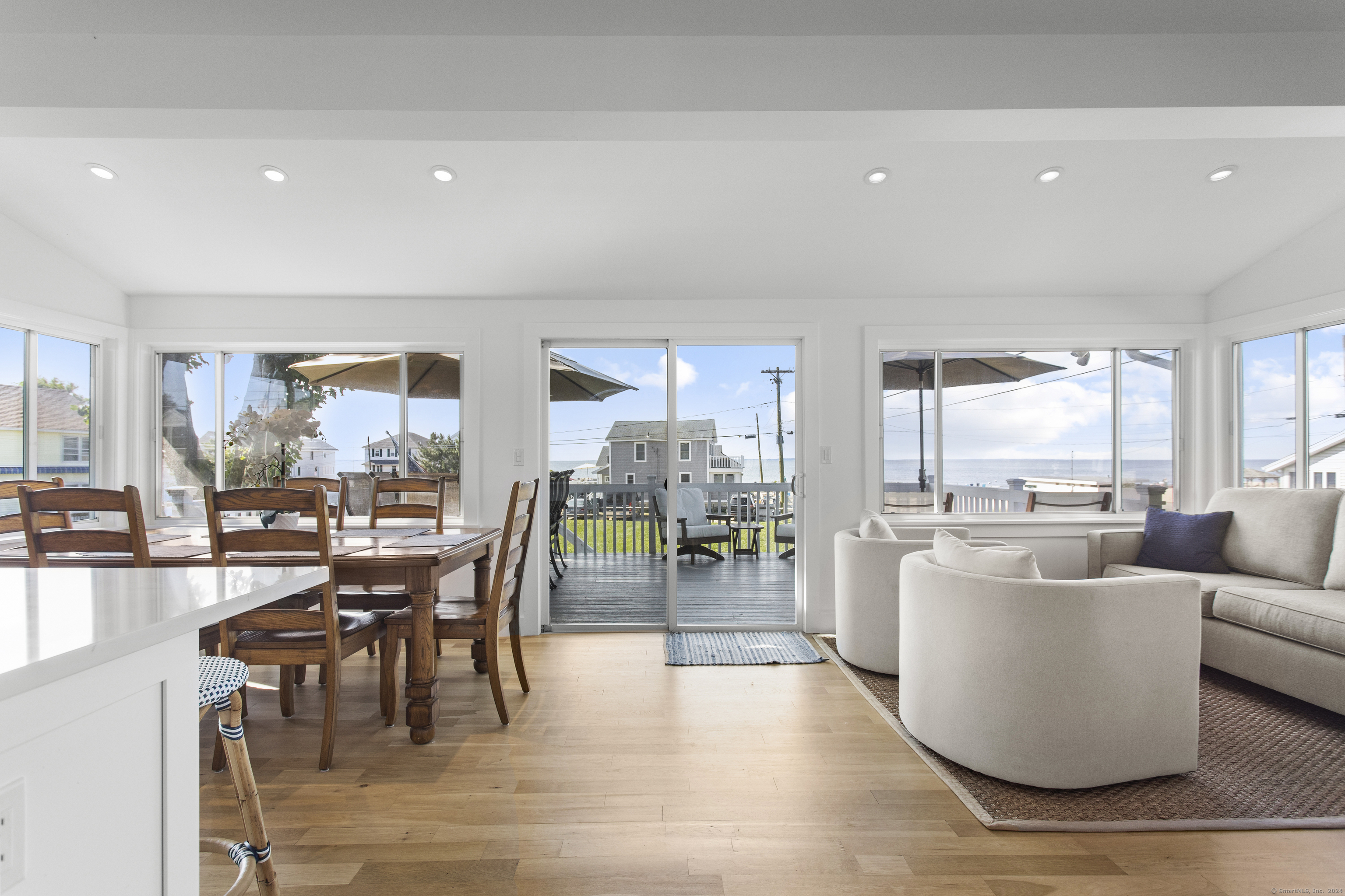 a living room with furniture a large window and wooden floor