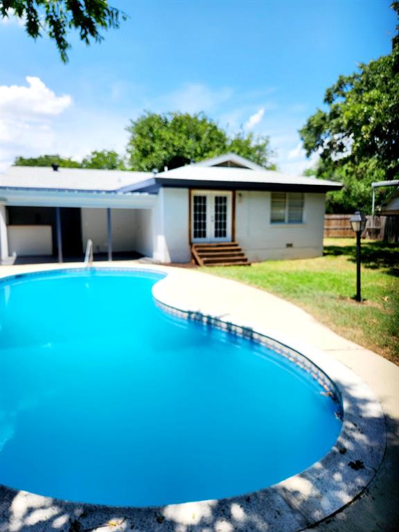 a view of a house with pool and a yard