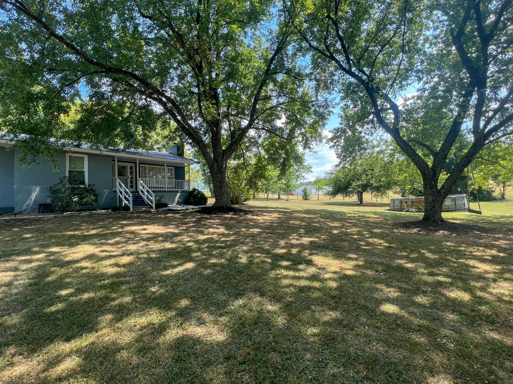 a view of a house with backyard and trees