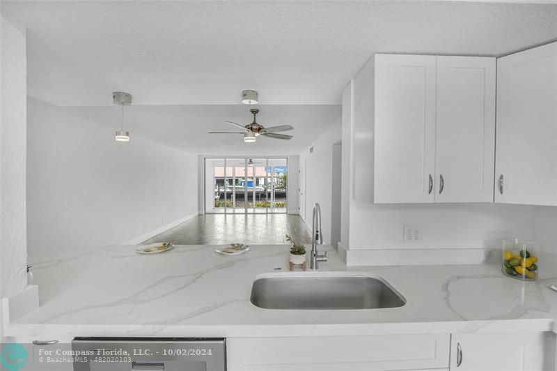 a kitchen with granite countertop a toilet a sink and cabinets