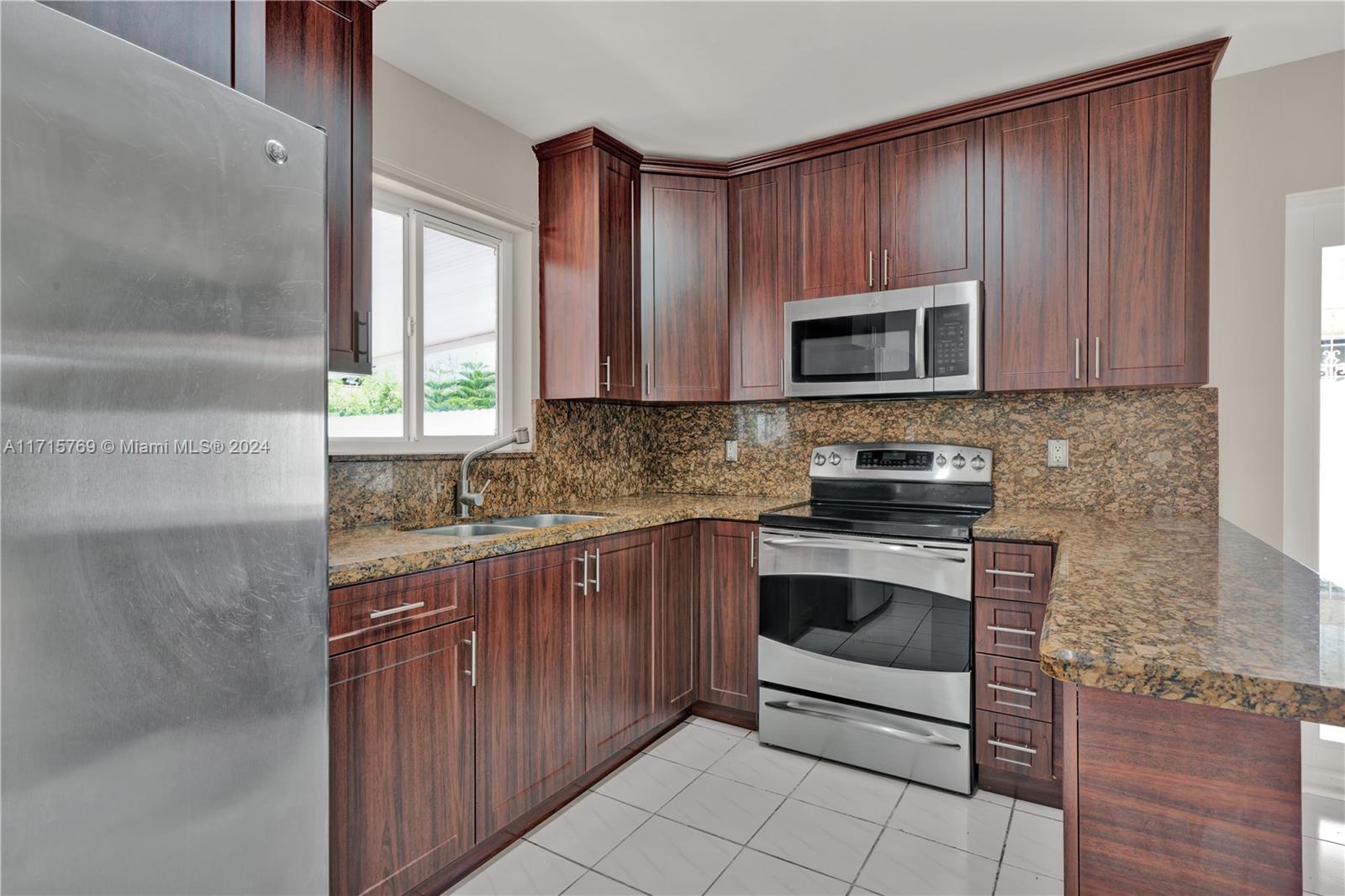 a kitchen with stainless steel appliances granite countertop a stove a sink and a microwave