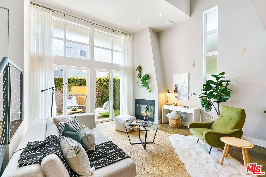 a living room with furniture fireplace and a large window