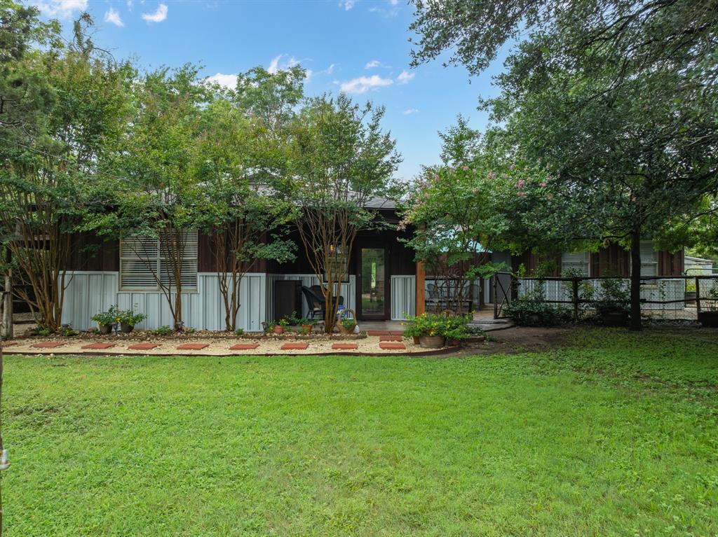 a front view of a house with a yard and trees