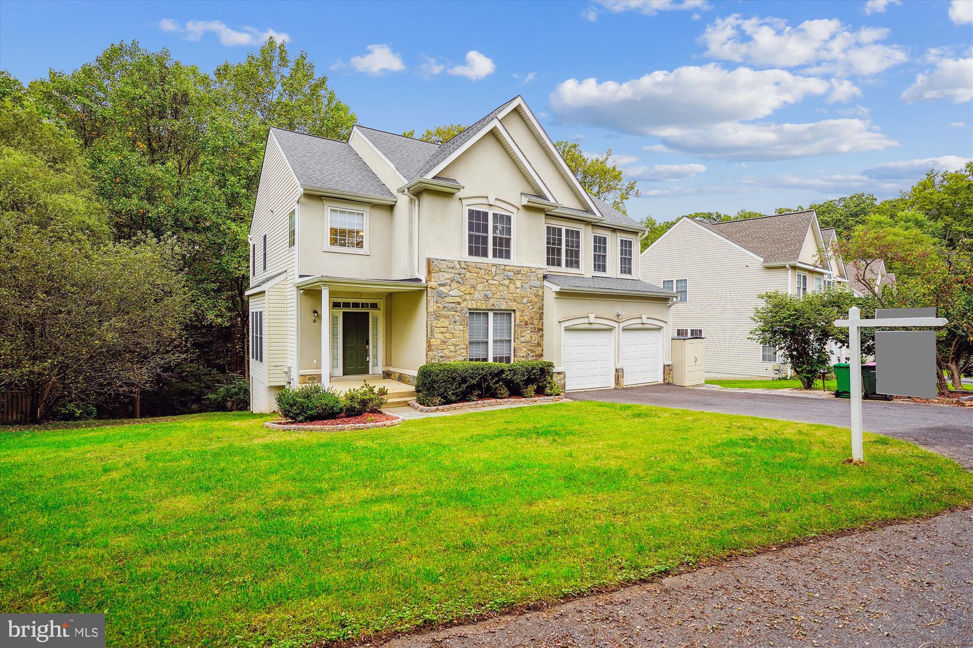 a front view of a house with a yard and trees