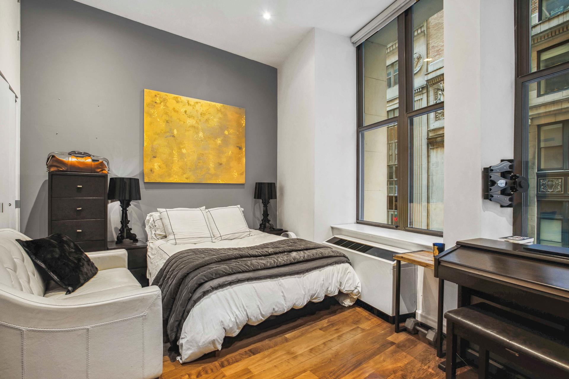 a bedroom with a bed and a flat tv screen on dresser