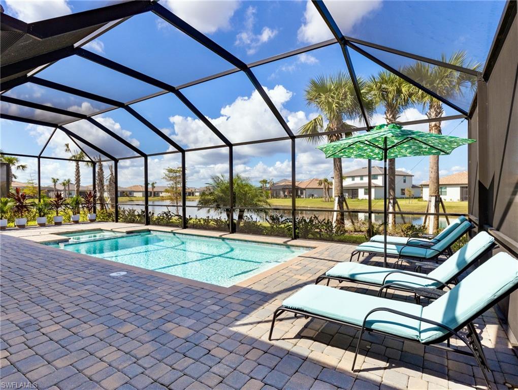 View of swimming pool featuring a patio and glass enclosure