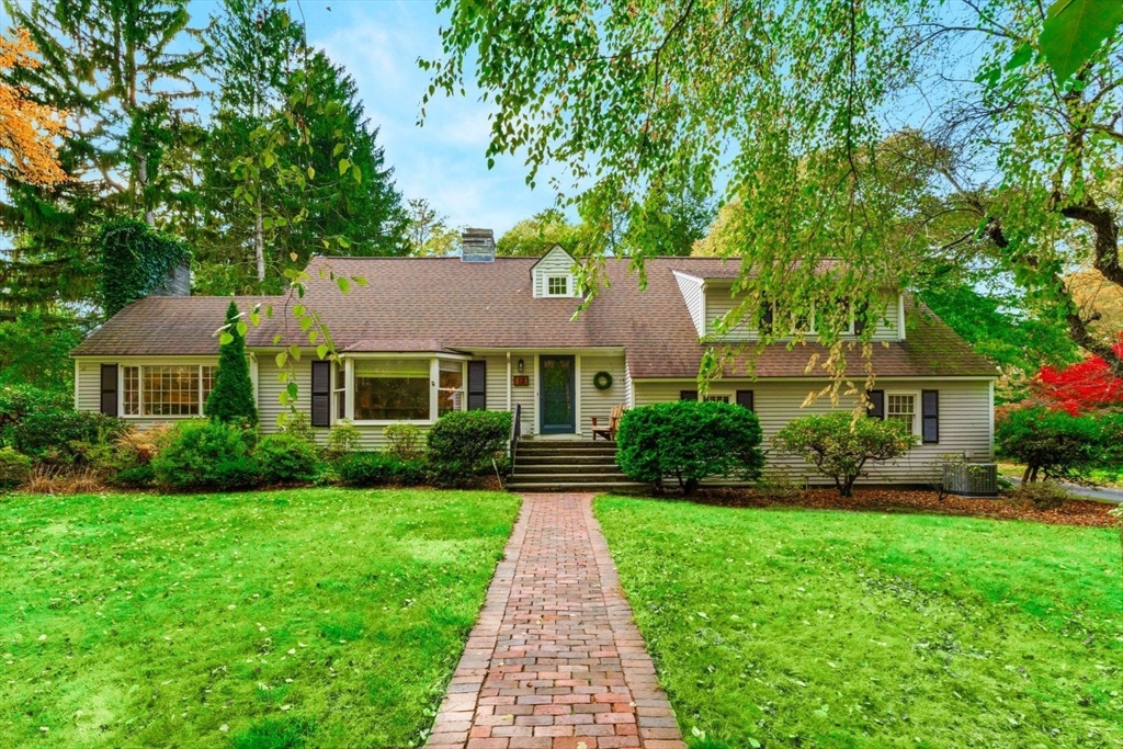 a front view of a house with a yard and potted plants