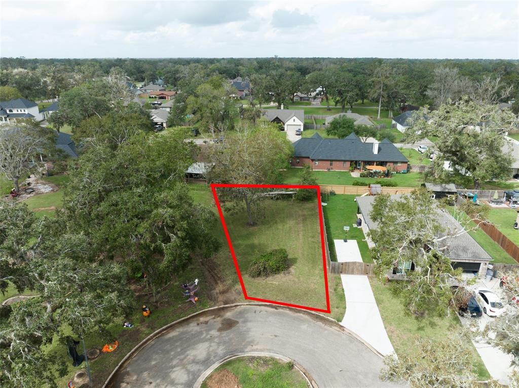 an aerial view of residential houses with outdoor space and trees