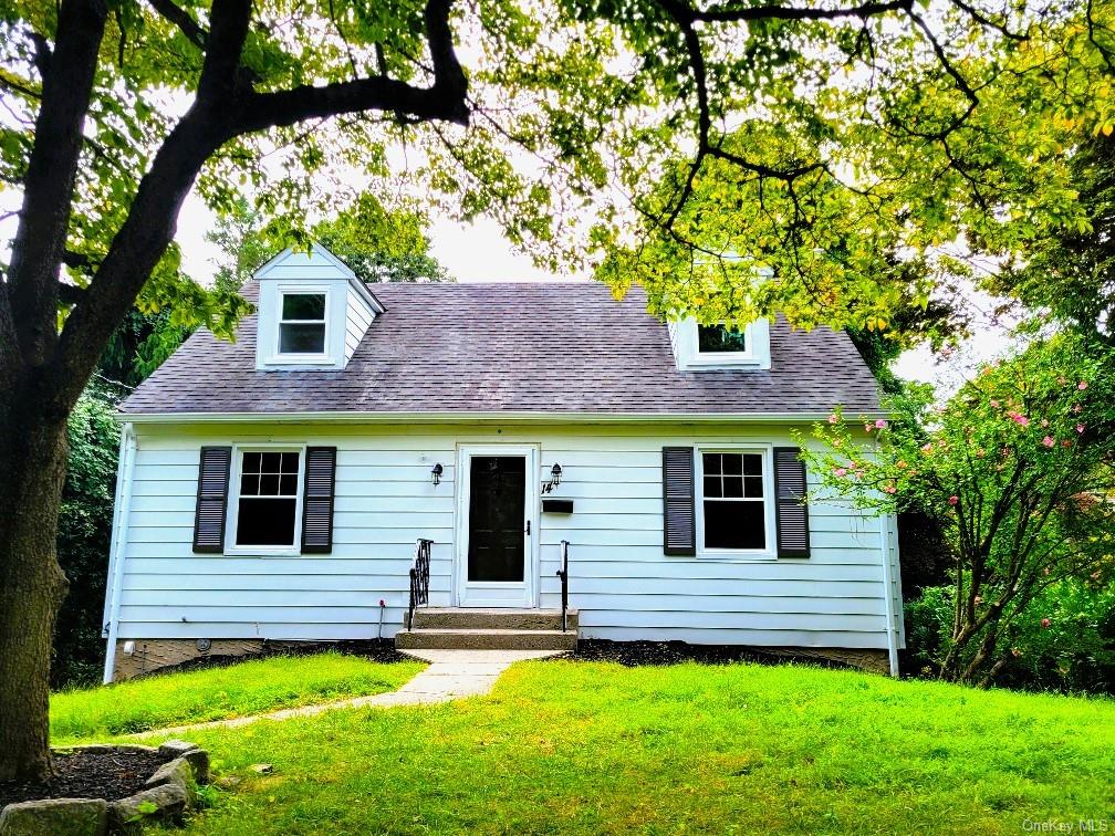 Cape cod home featuring a front lawn