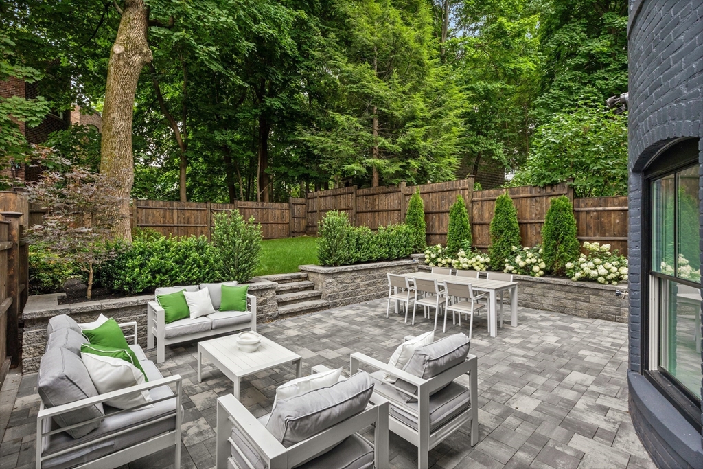 a view of backyard with outdoor seating and trees