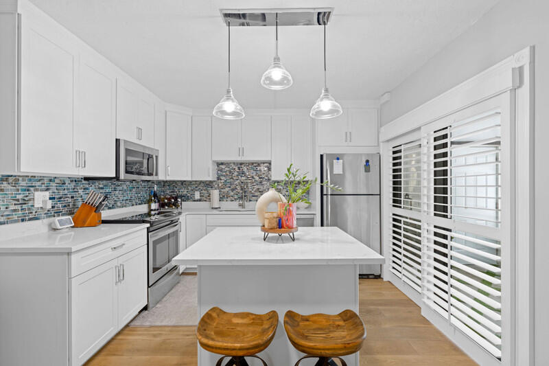 a kitchen with stainless steel appliances granite countertop a sink and a refrigerator